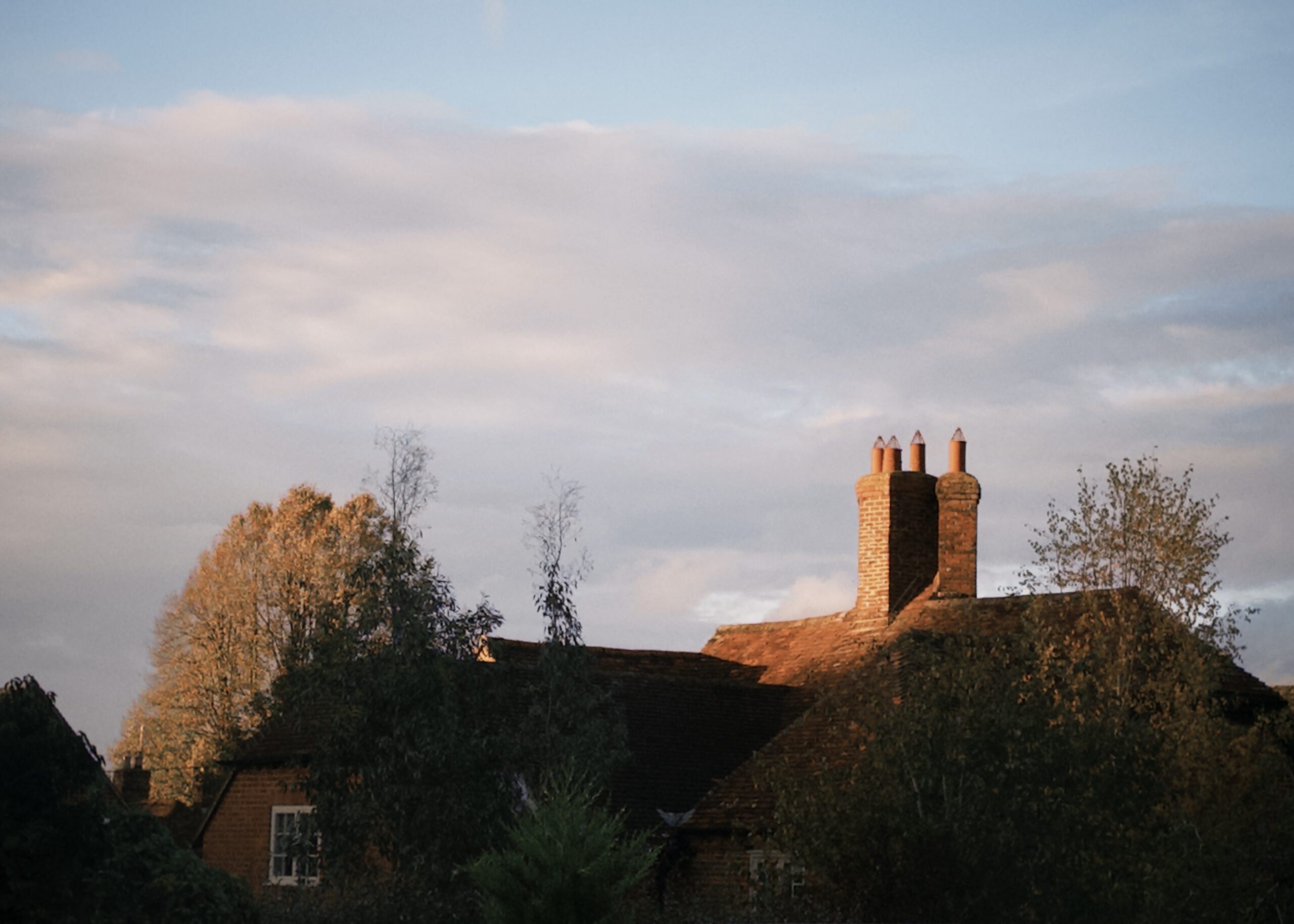 夕日に照らされたイギリスの家の屋根と煙突